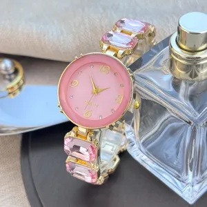 Chique dames quartz horloge met roze wijzerplaat, kristallen schakels en gouden metalen look.