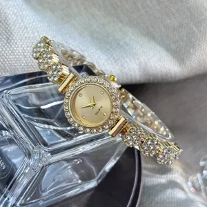Detailed close-up shot of women's gold quartz watch featuring sparkling rhinestones on bezel.