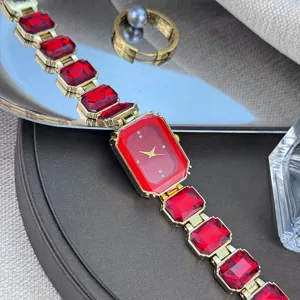 Rote Kristall Quarzuhr Detail mit elegantem quadratischem Edelstein Armband und goldenem Metall.