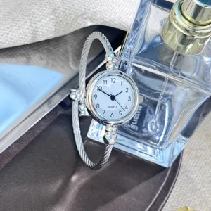 Silberne minimalistische Quarzuhr für Damen, elegantes Armreif-Design mit weißem Zifferblatt.