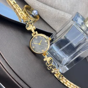 Elegante Damen Quarzuhr mit goldenem Schmetterlings-Kettenarmband und funkelnden Strasssteinen.