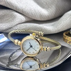 Elegante goldene Kabel-Armbanduhr mit Quarzwerk und klassischem runden Zifferblatt.