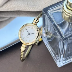 Elegante minimalistische goldfarbene Damen Armreif Quarzuhr mit feinem runden Zifferblatt.