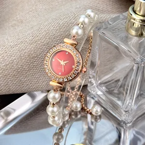 Elegant women pearl watch with diamond bezel red dial and adjustable bracelet strap detail.