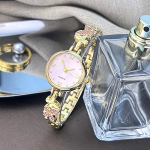 Elegante Damen Quarzuhr mit rosafarbenem Zifferblatt und goldfarbenem Schmetterlingsarmband.