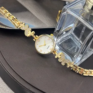 Elegante goldene Damen Quarz Armbanduhr mit Kristall Schmetterling Anhänger Zifferblatt.