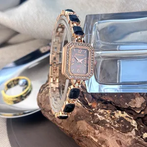 Elegante roségoldene Quarz-Uhr mit quadratischem Zifferblatt und schwarzem Kristallarmband.