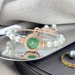 Close-up detail of luxury women's green dial quartz watch with pearl bracelet strap.