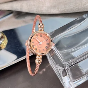 Nahaufnahme einer eleganten Roségold-Armspangen-Uhr mit gedrehtem Armband und Zifferblatt.