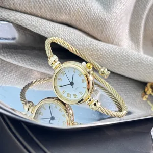 Elegante goldene Damen-Armbanduhr mit Kabel-Armreif und klassischem römischen Zifferblatt.