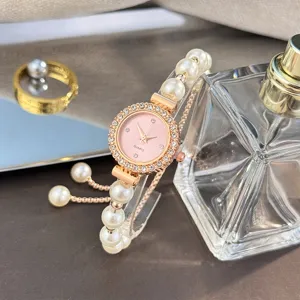 Elegant rose gold women quartz watch with pink dial rhinestone bezel and pearl bracelet strap.