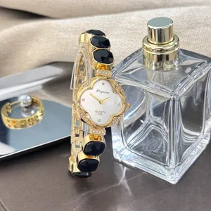 Reloj de pulsera de cuarzo para mujer con esfera de trébol y pedrería brillante.