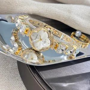 Elegante reloj de cuarzo de trébol con pedrería brillante y correa de cadena de metal brillante.