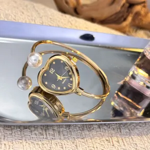 Goldene Armreif-Uhr mit Herz-Zifferblatt und doppelten Perlen modische Quarz-Armbanduhr