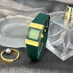 Grüne quadratische Silikonarmband Quarzuhr mit goldenen Akzenten und Kristallindizes.