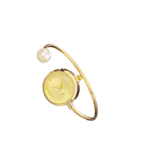 Elegante Perlen Armreif Uhr fuer Damen mit facettiertem Zifferblatt und glitzernden Strasssteinen.