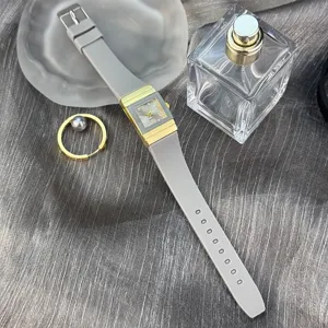 Minimalistische rechteckige Quarzuhr mit grauem Silikonarmband und goldenem Gehäuse, retro.