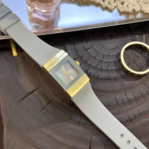 Rechteckige Quarzuhr mit grauem Silikonarmband und goldfarbenem Gehäuse für tägliches Tragen.