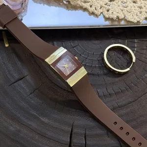 Braune Silikonarmband Quarzuhr mit rechteckigem Goldgehäuse und Strass-Zifferblatt.