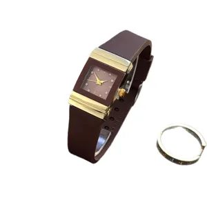 Vintage quadratische Quarzuhr mit braunem Silikonarmband und goldenem Metallgehaeuse.