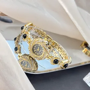 Elegante Damen Gold Quarz Uhr mit Strasssteinen und schwarzem Stein Armband Design Detail