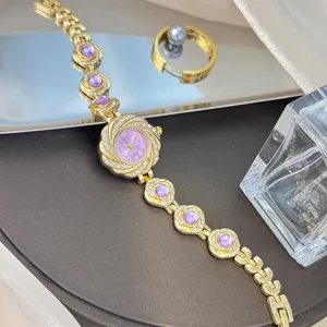Damen Armbanduhr Quarz goldfarben mit lila Kristallsteinen Luxus Mode elegante Armbanduhr.