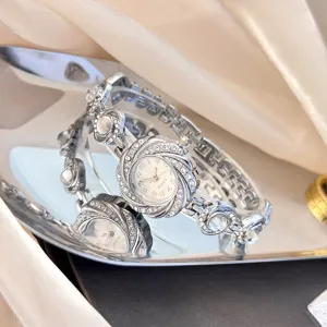Nahaufnahme der silbernen Damen Quarz Armbanduhr mit Strass und elegantem Blumen Zifferblatt.