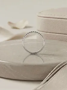 Delicate half-eternity diamond thin ring detail showcasing sparkling pavé stones on silver band.