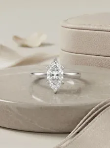 Exquisite close-up detail showcasing the brilliant marquise moissanite ring on a stone display.