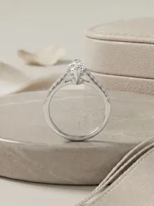Gedetailleerd overzicht van marquise moissaniet ring close-up op stenen sokkel, elegante sieraden.