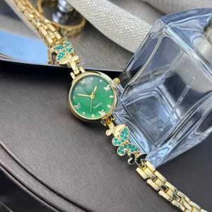 Elegante Damen Quarz-Armbanduhr mit gruenem Zifferblatt und goldenem Schmetterlingsarmband.