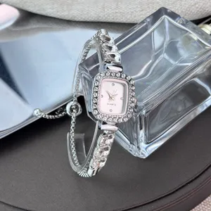 Close-up of a silver rhinestone quartz watch with square dial and adjustable bracelet strap.