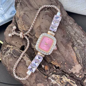 Close-up view of a rose gold quartz watch with pink crystal links and adjustable chain strap.
