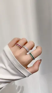 Primo piano dettagliato di anelli sandwich in argento sterling con pietre multiple.
