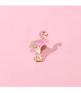 Close-up detail of a cute pink flamingo roller skate enamel brooch, charming metal bag badge.