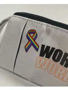Primer plano detallado de un estuche de lona gris con insignia de cinta de arcoiris.