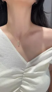 Close-up of a delicate gold clover pendant clavicle chain, elegant jewelry detail view.