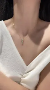 Close-up detail of a delicate gold-plated 925 silver necklace featuring three clover pendants.