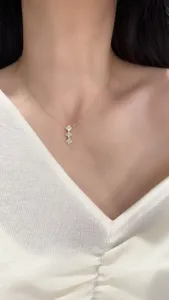 Detailed close-up shot of a elegant gold-plated multi-clover pendant necklace worn gracefully.
