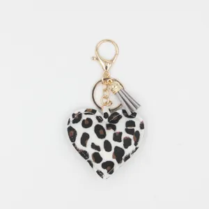 Leopard print heart keychain detail shot, featuring a stylish grey tassel and gold metal hardware.