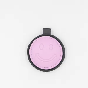Pink and black leather smiley face keychain detail, cute bag pendant and car accessory.