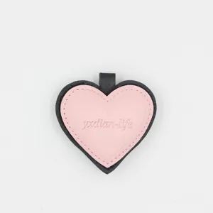 Detailed close-up of the stylish pink and black heart leather keychain and cute bag pendant.