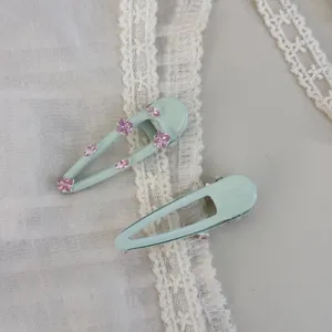 Mintgrüne Haarspangen mit rosa Strasssteinen Detail, elegante Seitenklammer für das modische Haar.
