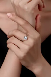 Nahaufnahme Detail eines silbernen Solitär Moissanit Rings an Hand, elegant funkelnd.