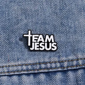 Close-up detail of the metal enamel brooch pin featuring inspirational lettering against denim.