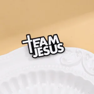 Detailed close-up of the black and white Team Jesus cross enamel brooch pin, stylish decor.
