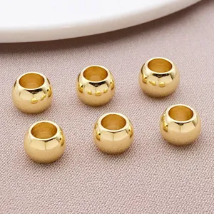 Close-up detail of smooth gold-plated large-hole spacer beads for DIY jewelry making.