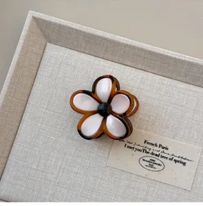 Gedetailleerd overzicht van een chique bloemen haarhaakje van acetaat voor mooie kapsels.