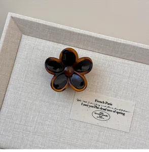 Bruine bloemige haarklauwclip, minimalistisch hars haaraccessoire voor dagelijkse styling.