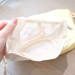 Detailed view of the off-white drawstring storage bag interior structure and design.